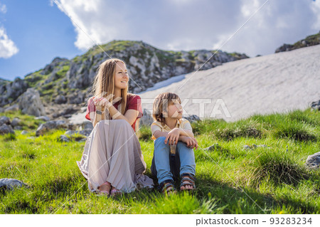 Family of tourists mom and son in Mountain lake landscape on Durmitor mountain in Montenegro beautiful Durmitor National park with lake glacier and reflecting mountain Portrait of a disgruntled girl 93283234