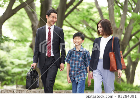 A family of three walking while showing a smile A family of three walking while showing a smile 93284391