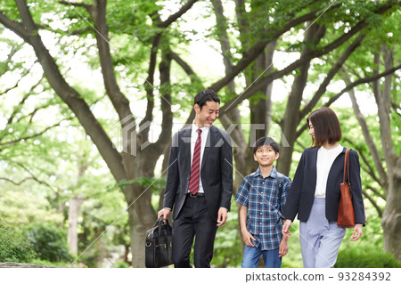 A family of three walking while showing a smile A family of three walking while showing a smile 93284392