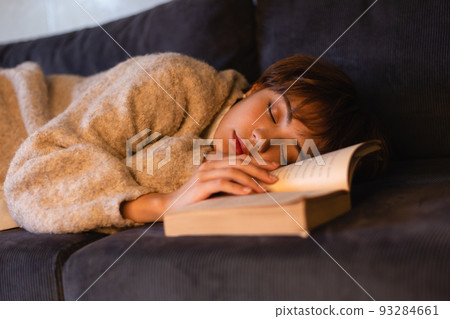 Young woman sleeping while reading a book 93284661