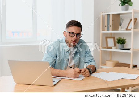 Serious friendly handsome stylish young businessman in eyewear talks with candidate at vacancy looks at camera reclines on table. Copy space for ad. Remote Job Technology And Career Profession Concept 93284695