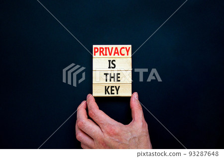 Privacy is the key symbol. Concept words Privacy is the key on wooden blocks on a beautiful black table black background. Businessman hand. Business, finacial and privacy is the key concept. 93287648