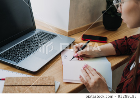 Taskmanager, To do List, Boosts Productivity, Close up of female hands and paper to do list in notepad Taskmanager, To do List, Boosts Productivity, Close up of female hands and paper to do list in notepad 93289185