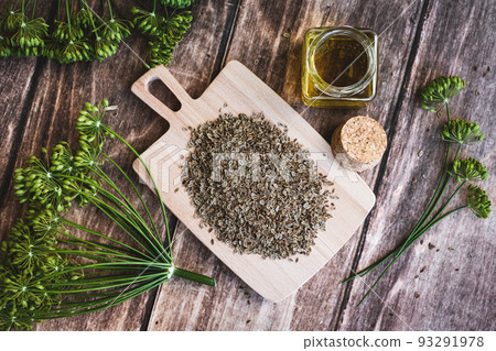 Dill flowers and dry seeds, Anethum graveolens essential cosmetic oil in bottle on wooden background, overhead flat lay Dill flowers and dry seeds, Anethum graveolens essential cosmetic oil in bottle on wooden background, overhead flat lay 93291978