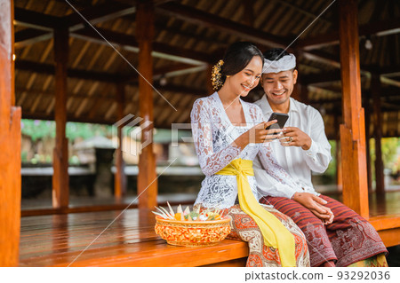 portrait of balinese couple using mobile phone portrait of balinese couple using mobile phone 93292036
