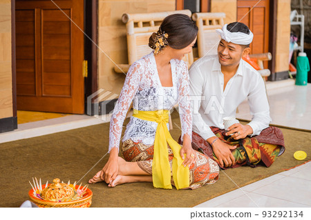 balinese couple sitting on the floor at their house talking to each other balinese couple sitting on the floor at their house talking to each other 93292134