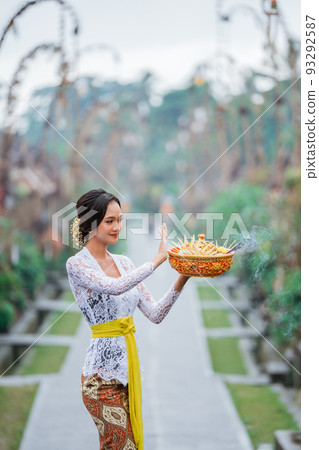 balinese woman carrying an holy offering for praying to god balinese woman carrying an holy offering for praying to god 93292587