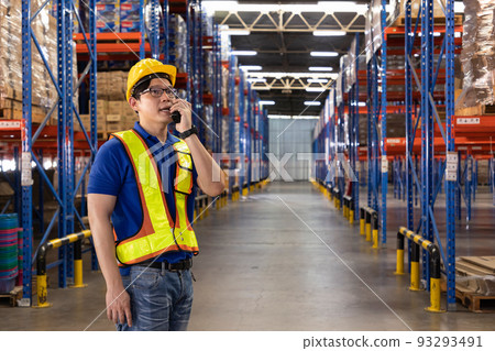 Foreman using walkie-talkie control loading while organizing package shipment for distribution. Foreman using walkie-talkie control loading while organizing package shipment for distribution. 93293491