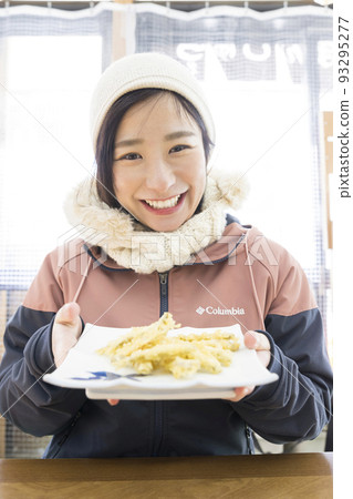Young woman showing fried smelt 93295277