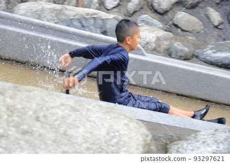 Male junior high school student (12 years old) playing on a river waterslide 93297621