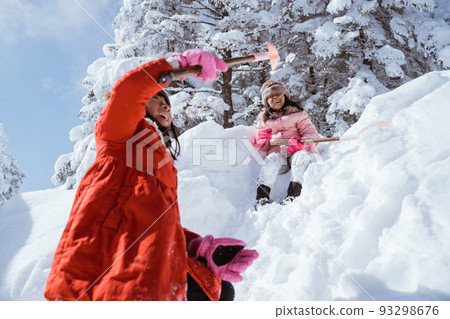 asian little sister playing in snowy winter together 93298676