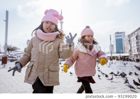 two little girl playing chasing a bird in istanbul taksim 93299020