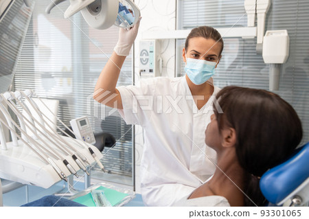 Young African American woman sitting in dentists chair 93301065