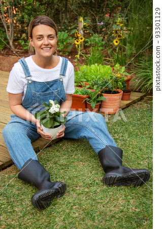 Pleased woman with potted plant Pleased woman with potted plant 93301129
