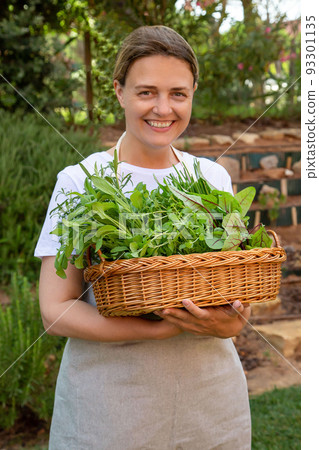 Pleased woman holding salad seedlings 93301135