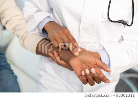 Close-up of doctor checking pulse 93301311
