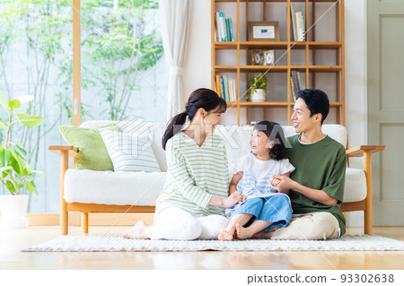 一個在客廳裡放鬆的年輕家庭 93302638