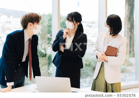 Business team wearing a mask and having a meeting Business team wearing a mask and having a meeting 93302876