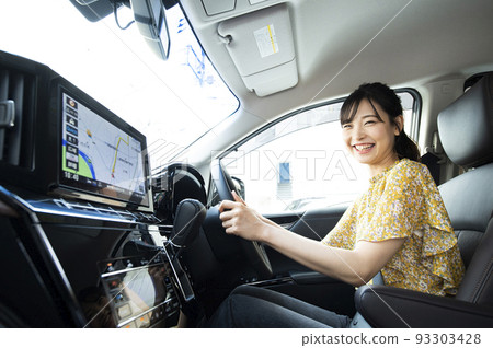 A young woman driving a car 93303428