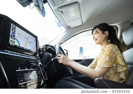 A young woman driving a car 93303430