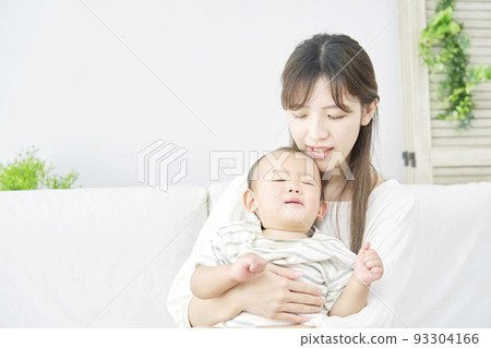 A mother comforting a fussy baby in the living room 93304166