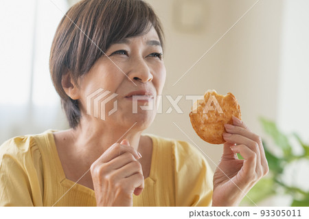 Middle woman eating rice cracker Middle woman eating rice cracker 93305011
