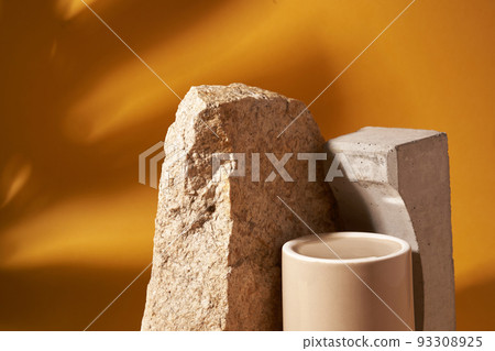 A design element with space to copy. A podium made of porcelain for product presentation on a background of beige stone. In the background, the shadow of the leaves of the monstera. High quality photo 93308925