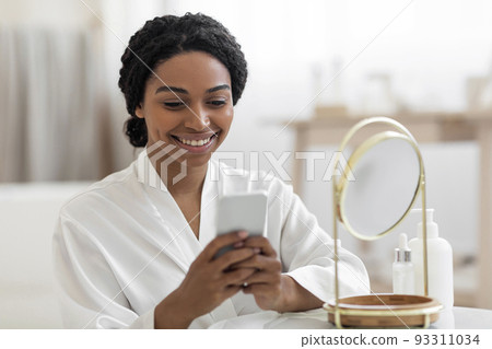 Black Woman With Smartphone Reading Beauty Hacks While Getting Ready At Home Black Woman With Smartphone Reading Beauty Hacks While Getting Ready At Home 93311034