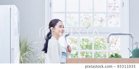 Housewife cooking in the kitchen of a newly built house Housewife cooking in the kitchen of a newly built house 93311035