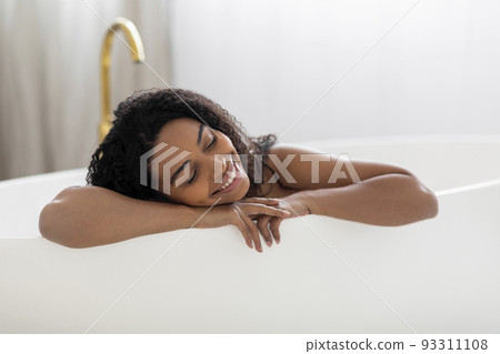 Beautiful Young African American Woman Relaxing In Luxury Bathtub At Home Beautiful Young African American Woman Relaxing In Luxury Bathtub At Home 93311108