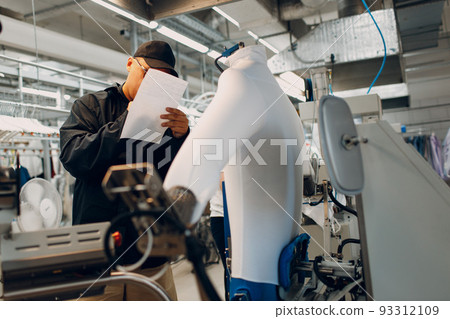 Worker working on Iron Dryer Mannequin steamer at Dry cleaning clothes. Clean cloth chemical process. Laundry industrial dry-cleaning. Worker working on Iron Dryer Mannequin steamer at Dry cleaning clothes. Clean cloth chemical process. Laundry industrial dry-cleaning. 93312109