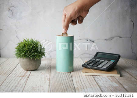 young man saving coins in a jar white sited 93312181