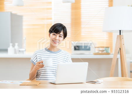 A woman taking a break during telework in the living room A woman taking a break during telework in the living room 93312316