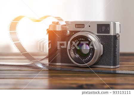 Vintage photo camera and photo film in shape of heart on wooden table. Vintage photo camera and photo film in shape of heart on wooden table. 93313111
