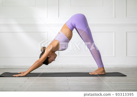 Side view of Asian woman wearing purple sportwear doing Yoga exercise,Yoga Child pose or Balasana. Calm of healthy young woman breathing and meditation with yoga at home. Exercise for wellness life Side view of Asian woman wearing purple sportwear doing Yoga exercise,Yoga Child pose or Balasana. Calm of healthy young woman breathing and meditation with yoga at home. Exercise for wellness life 93313395
