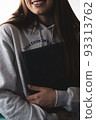 Student woman holding stack of notebooks. Student with a stack of notepads. Girl holding books in her hands. 93313762
