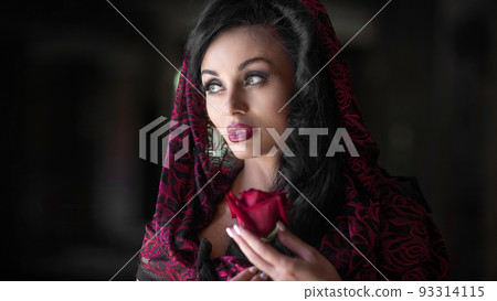 Close-up portrait of a young woman with a red rose. 93314115