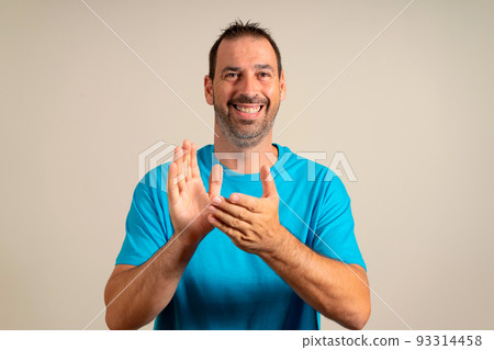 Handsome middle age latin man standing together over isolated background clapping hands and clapping happy and joyful, smiling. 93314458