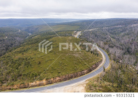 Drone aerial photograph of a highway running through a forest in regional Australia. 93315321