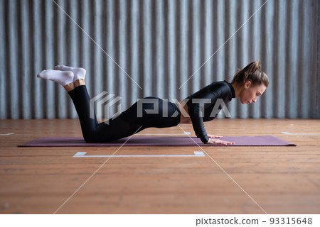 Fit woman doing push ups from knees 93315648