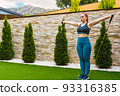 young sportswoman, stretching her body muscles with elastic bands outdoors in the garden of her house. concept of health and well-being. 93316385