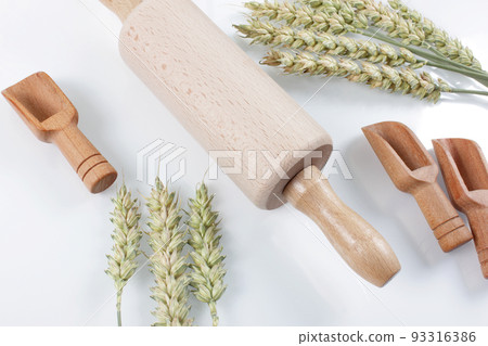 Rolling pin with wheat and spoons isolated on white background.  93316386