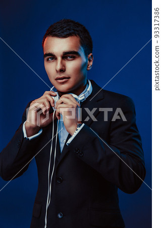 Portrait of man with headphones on dark background. Studio shoot Portrait of man with headphones on dark background. Studio shoot 93317386