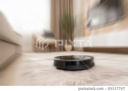 automatic carpet cleaning in a modern apartment robot vacuum cleaner with motion blur effect 93317747