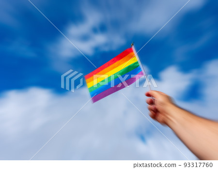 LGBT flag in hand against the sky with motion blur effect 93317760