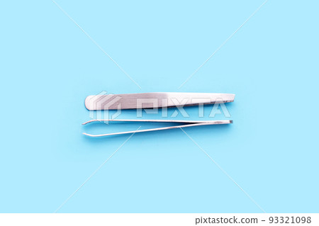 Tweezers on blue background. Copy space 93321098