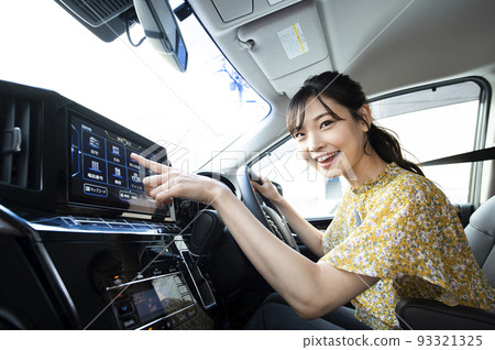 Young woman operating car navigation Young woman operating car navigation 93321325