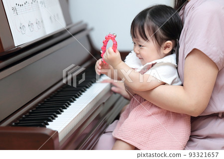 1 year old girl and mom playing upright piano 1 year old girl and mom playing upright piano 93321657
