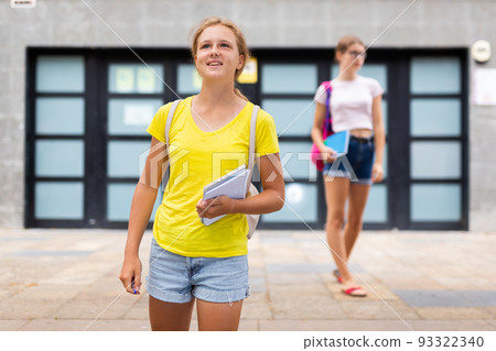 Cute teen girl walking down street to school 93322340