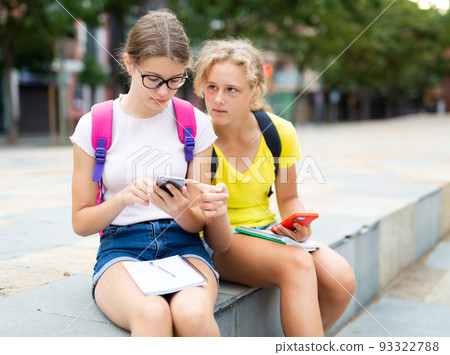 Two schoolgirls doing their homework outdoors 93322788